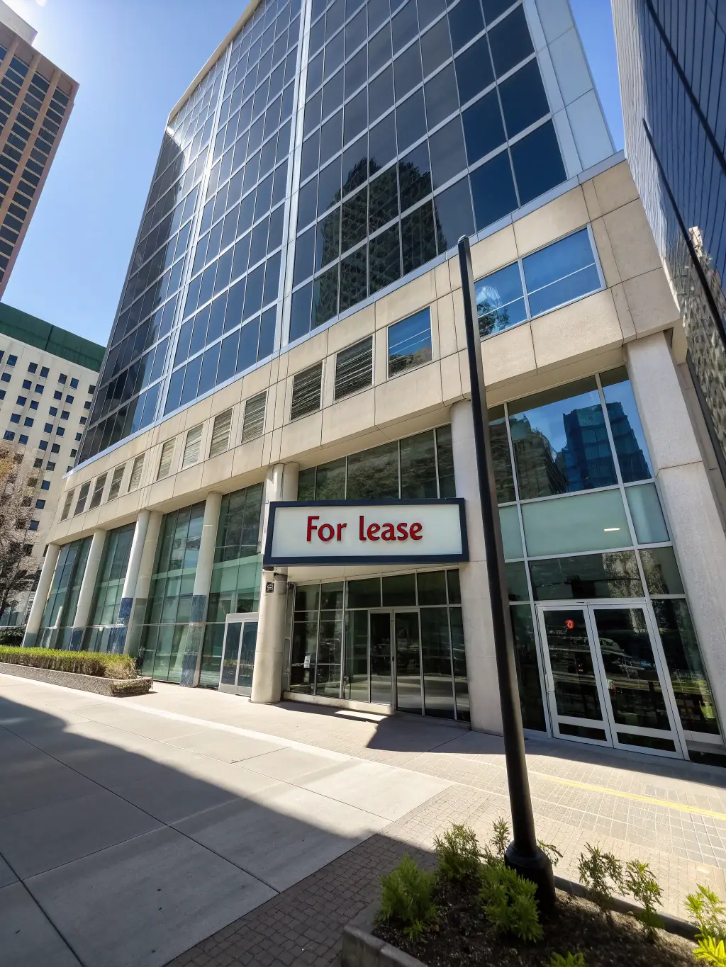 A modern office building with a 'For Lease' sign, representing commercial real estate financing options for businesses.